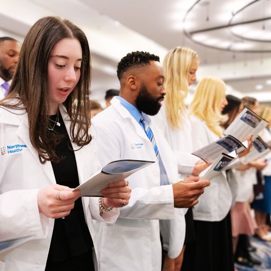 students in white coat reading oath